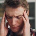 “지친 하루의 반복, 만성피로를 벗어나기 위한 작은 변화들” a man holding his hands to his ears