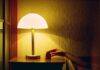 집에서 쉽게 실천하는 ‘스마트한 수면 루틴’이 주목받는다 a person's hand on a table next to a lamp