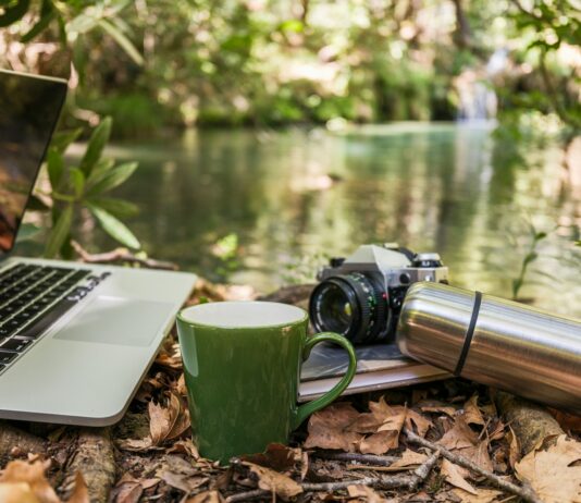 “잘 자야 내일이 가볍다”…당신의 수면 습관, 최신 트렌드로 바꿔볼 때 Laptop, camera, and mug by a forest stream