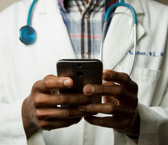 디지털 헬스케어, 손안의 건강관리 혁명 person wearing lavatory gown with green stethoscope on neck using phone while standing
